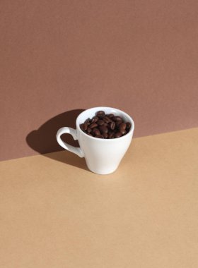 Kahverengi sırtüstü kahve çekirdekli seramik fincan. Gölgeli. Yaratıcı yerleşim