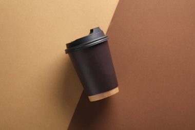 Kahverengi arka planda tek kullanımlık karton bardak. Üst görünüm