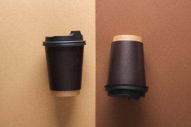 Kahverengi bej arka planda tek kullanımlık karton bardaklar. Üst görünüm