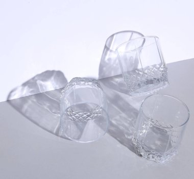 Gri beyaz arka planda gölgesi olan boş bir cam. Yaratıcı yerleşim