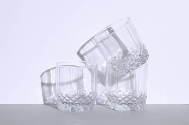 Gri beyaz arka planda gölgesi olan boş bir cam. Yaratıcı yerleşim