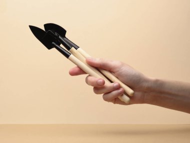 Kahverengi arkaplanda minyatür bahçe aletleri (tırmıklar, kürekler) seti.