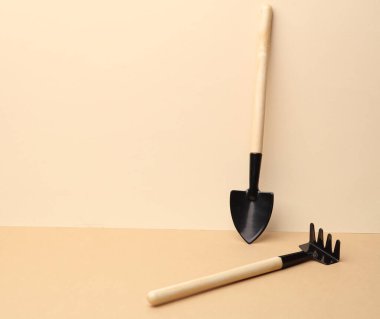Kahverengi arkaplanda minyatür bahçe aletleri (tırmıklar, kürekler) seti. Yaratıcı yerleşim