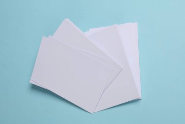 Mavi arkaplanda beyaz boş kağıt ya da fotoğrafların maketi