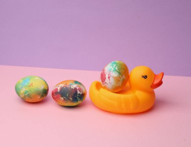 Pastel arka planda Paskalya yumurtası ve plastik ördek. Minimalizm Paskalyası