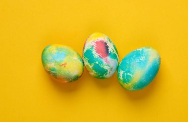 Sarı arka planda çok renkli Paskalya yumurtaları