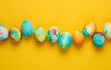 Sarı arka planda çok renkli Paskalya yumurtaları