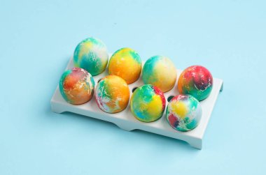 Tepside renkli Paskalya yumurtaları, mavi arka plan.