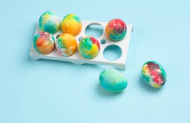 Tepside renkli Paskalya yumurtaları, mavi arka plan.