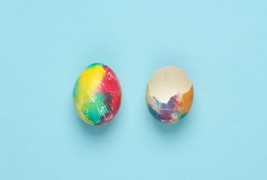 Mavi arka planda tam ve kırık bir Paskalya yumurtası. Asgari paskalya kavramı