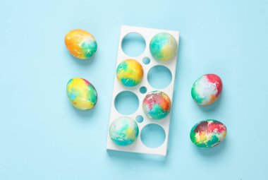 Tepside renkli Paskalya yumurtaları, mavi arka plan. Üst görünüm