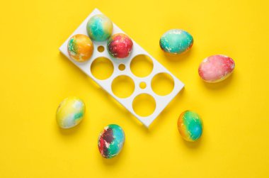Sarı arka planda renkli Paskalya yumurtaları..