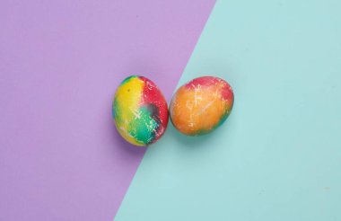 Pastel arka planda renkli Paskalya yumurtaları. Yaratıcı düzen. Üst görünüm