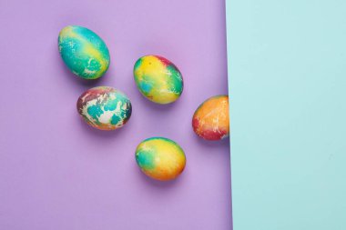 Pastel arka planda renkli Paskalya yumurtaları. Yaratıcı düzen. Üst görünüm