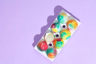 Mor arka planda gölgeli renkli Paskalya yumurtaları. Yaratıcı yerleşim