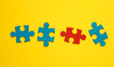 Sarı arka planda mavi ve kırmızı yapboz parçaları. İş konsepti