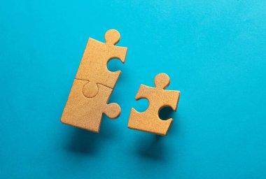 Mavi arkaplandaki altın yapboz parçacıkları. İş konsepti