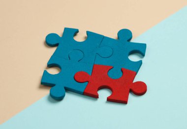 Pastel arka planda mavi ve kırmızı yapboz parçacıkları. İş konsepti