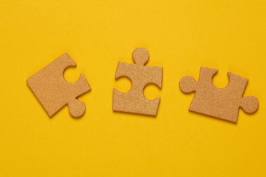 Sarı arka planda altın yapboz parçaları. İş konsepti