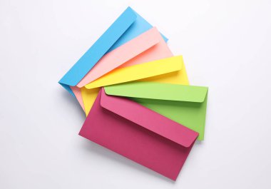 Beyaz arka planda bir grup renkli zarf. Yaratıcı yerleşim