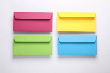 Beyaz arka planda bir grup renkli zarf. Yaratıcı yerleşim