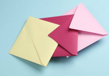 Mavi arkaplanda üç kare renkli zarf.