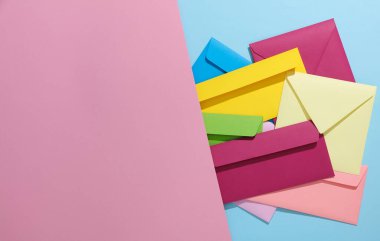 Pembe mavi arka planda renkli zarflar. Yaratıcı yerleşim
