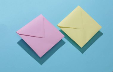 Mavi arkaplanda iki kare renkli zarf.