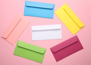 Pembe arka planda renkli zarflar. Yaratıcı yerleşim