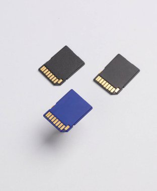 Gri arkaplanda üç tane SD hafıza kartı var. Yaratıcı yerleşim