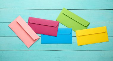 Mavi ahşap tahtalarda renkli zarflar. Yaratıcı yerleşim