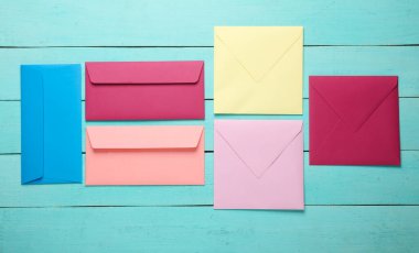 Mavi ahşap tahtalarda renkli zarflar. Yaratıcı yerleşim