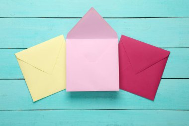 Mavi ahşap tahtalarda renkli zarflar. Yaratıcı yerleşim