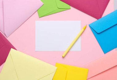 Kalem ve lavanta rengi arka planda renkli zarflarla dolu boş bir mektup kağıdı. Tasarım için şablon, davet