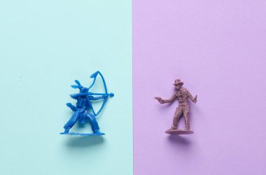 Pastel arka planda Kızılderili ve kovboy figürleri. Vahşi Batı