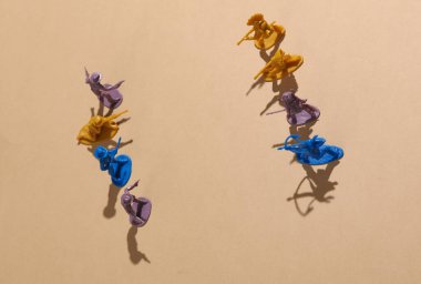 Vahşi batı sahnesi. Plastik kovboy ve bej arka planda Amerikan Kızılderili çatışması