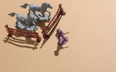 Vahşi Batı. Oyuncak kovboy atları korur.