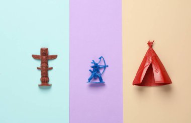 Plastik Amerikan askeri, wigwam ve Idol pastel arka planda. Yaratıcı yerleşim