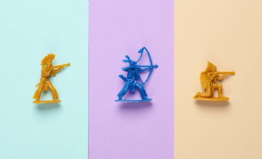 Pastel arka planda plastik Amerikan askerleri. Vahşi batı, batı. Minimalizm