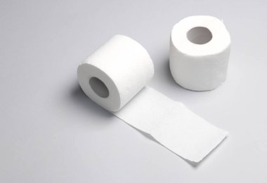 Mavi arka planda iki rulo beyaz tuvalet kağıdı.