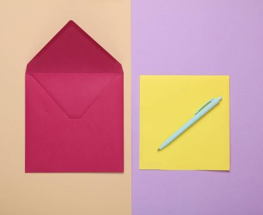 Sarı harfli mor zarf ve pastel arka planda kalem.