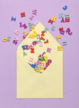 Sarı zarf ve mor renkli arka planda bir sürü harf