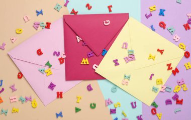 Renkli zarflar ve pastel arka planda bir sürü harf.