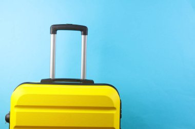 Sarı bavul, seyahat çantası ya da mavi arka planda valiz. Yaz tatili, seyahat, taşınma konsepti..