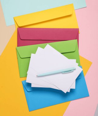 Renkli arkaplanda beyaz boş bir harf olan renkli zarflar.