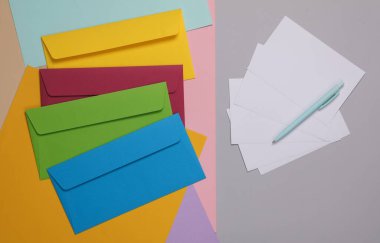 Renkli arkaplanda beyaz boş bir harf olan renkli zarflar.