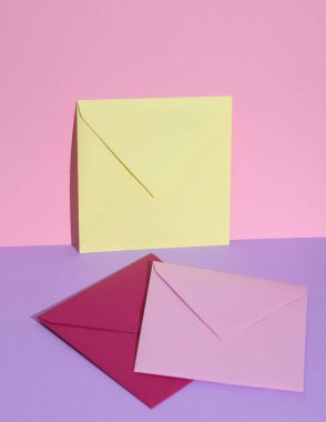 Pastel parlak arkaplanda renkli zarflar olan yaratıcı bir düzen. Minimalizm