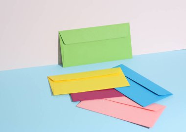 Pastel parlak arkaplanda renkli zarflar olan yaratıcı bir düzen. Minimalizm