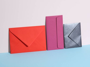 Pastel parlak arkaplanda renkli zarflar olan yaratıcı bir düzen. Minimalizm