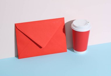 Kırmızı kahve fincanı ve pastel parlak arka planda zarflı yaratıcı bir düzen. Minimalizm